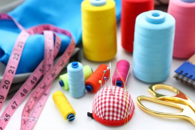 Set of threads and needles lying at worktable