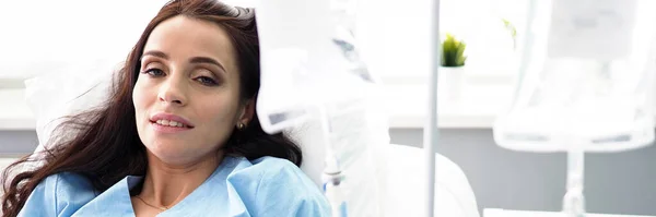 Больная женщина лежит на больничной койке с капельницей — стоковое фото