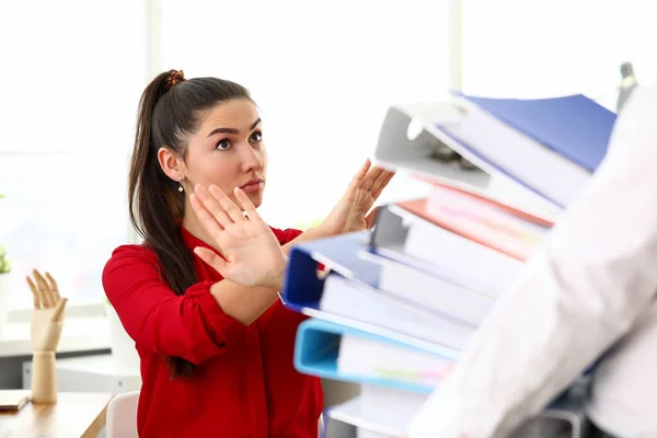 Young happy woman sitting in office and refusing to work with heap of documents — Stock Photo, Image