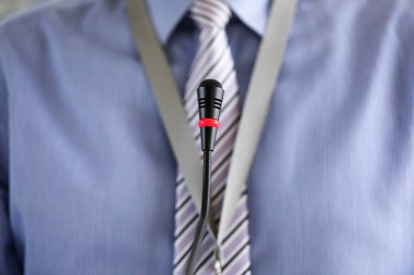 Konferans mikrofonunda duran kravat takan adam.