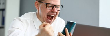 Erkek yönetici akıllı telefona bakarken bağırıyor ve ifade ediyor