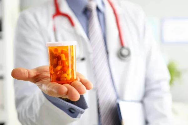 Manlig medicin läkare hand hålla och erbjuda patienten burk med piller — Stockfoto