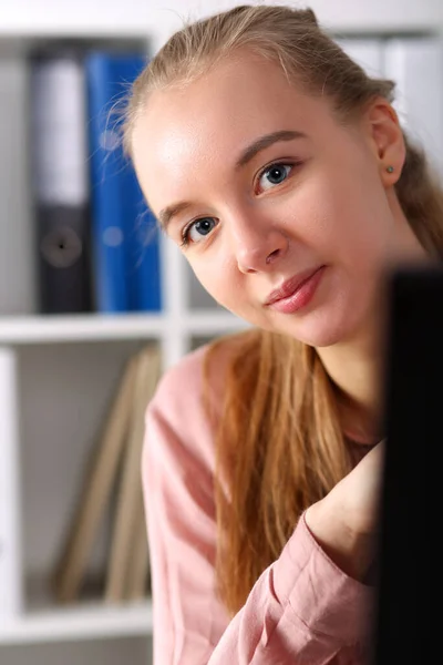 Werkplaats meisje gluurt uit van achter monitor — Stockfoto