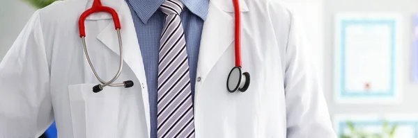 Stethoscope lying on male doctor chest in office — Stock Photo, Image