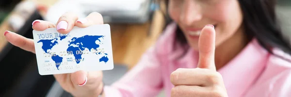 Girl in office shows bank card and ok gesture — Stock Photo, Image