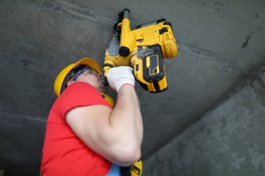 İnşaatçı beton yumruklayıcı ile tavanda çalışır