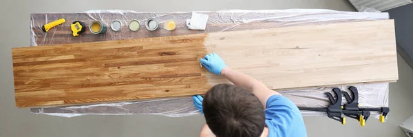 Woodworker varnishing surface — Stock Photo, Image