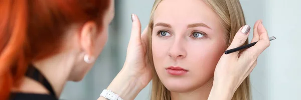 Make-up umělec se dívá na symetrické modely obočí — Stock fotografie