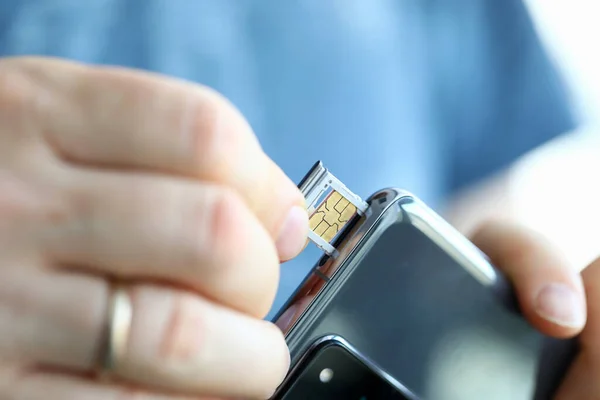 Manos masculinas conseguir ranura para tarjetas SIM de su teléfono inteligente —  Fotos de Stock
