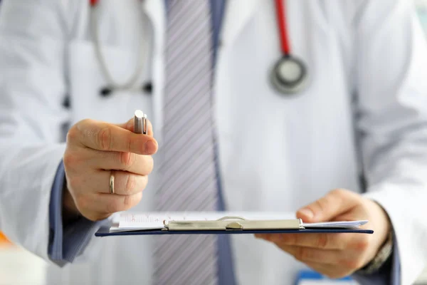 Mano de GP masculino pasando a paciente pluma de plata pidiendo firmar algunos documentos — Foto de Stock