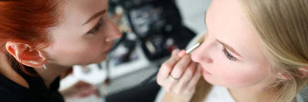 Maskenbildnerin macht Make-up für blondes Mädchen — Stockfoto