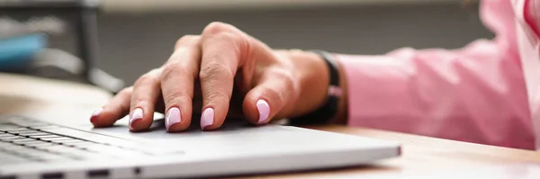 Vrouwelijke hand met mode manicure ligt in de buurt laptop — Stockfoto