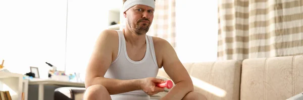 Homem em casa sentado na bola em mãos haltere — Fotografia de Stock