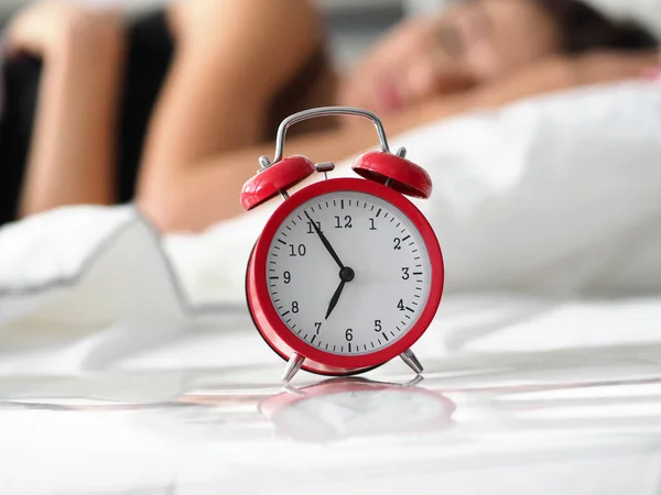 Red old fashioned alarm clock set at seven in morning Royalty Free Stock Images