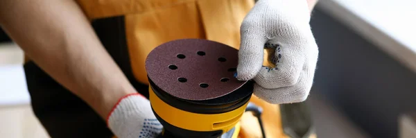 Muž v pracovních rukavicích drží nástroj bruska stroj — Stock fotografie