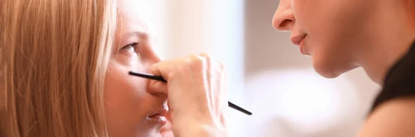 Artista de maquiagem feminina trabalha com olhos modelo feminino — Fotografia de Stock