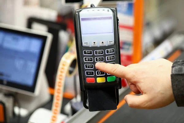 Mano masculina que teclea la tarjeta del código del perno mientras que paga con él en el mostrador del efectivo del supermercado —  Fotos de Stock