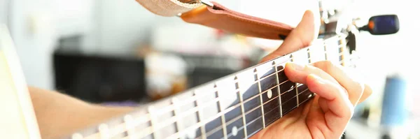 Hombre toca la guitarra, mano masculina sostiene la guitarra del cuello — Foto de Stock