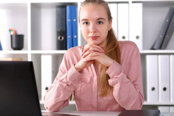 Девушка сидит в офисе на рабочем месте перед ноутбуком — стоковое фото