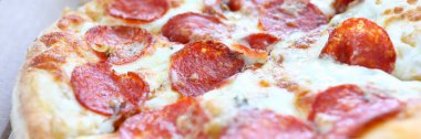 Fırında taze pizza, kabuklu peynir ve yemeye hazır sıcak biberli pizza.