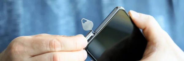 Man trekt SIM-kaart slot voor nieuwe telefoon met pin — Stockfoto