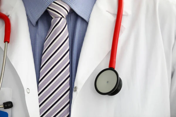 Stethoscope lying on male therapeutist doctor chest — Stock Photo, Image