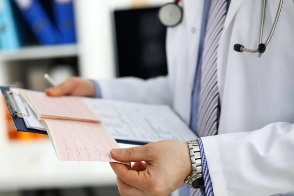 Male medicine doctor hands holding cardiogram chart — Stock Photo, Image