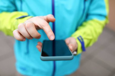 Ceketli adam ekrandaki telefona tıklıyor.