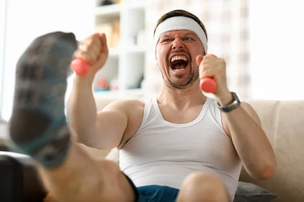 Cara fazendo exercícios com halteres em suas mãos — Fotografia de Stock