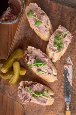 Yeşiller ve çeşniler ekmek dilimleri üzerine yayılmış pate.