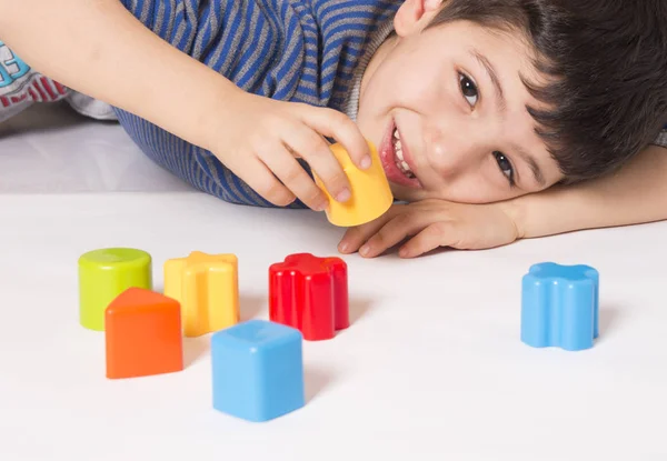 Jongen speelt met kleurrijke kubussen — Stockfoto