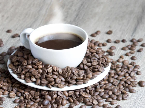 Taza de café en medio de granos de café — Foto de Stock