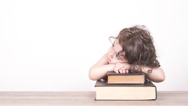 Gekrulde haired meisje droomt over haar boeken — Stockfoto