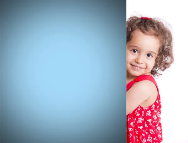 Menina pré-escolar mostrando parede azul — Fotografia de Stock