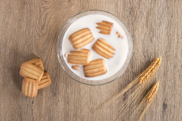 Baby biscuit and milk bowl with wheat spike — Stock Photo, Image