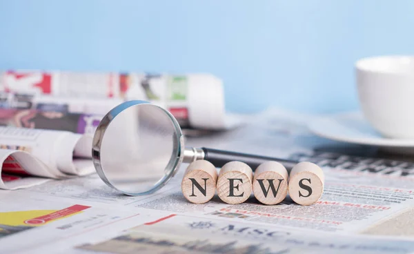 Newspaper and magnifying glass on the table, news wiritng on the — Stock Photo, Image