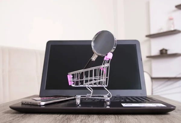 phone, credit card and shopping cart on computer