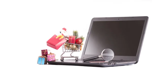 Bevásárló kosár tele karácsonyi kellékek-on laptop — Stock Fotó