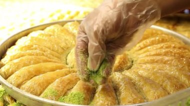 adam fıstık baklava dilimleri üzerine koyar