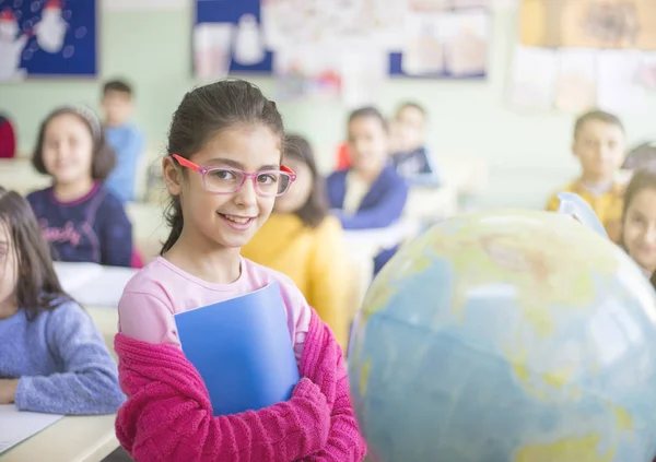 Estudante menina segurar notebook na sala de aula com esfera — Fotografia de Stock
