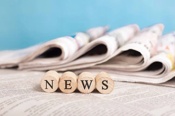 Writing "news" on cube in the front of the newspaper stack — Stock Photo, Image