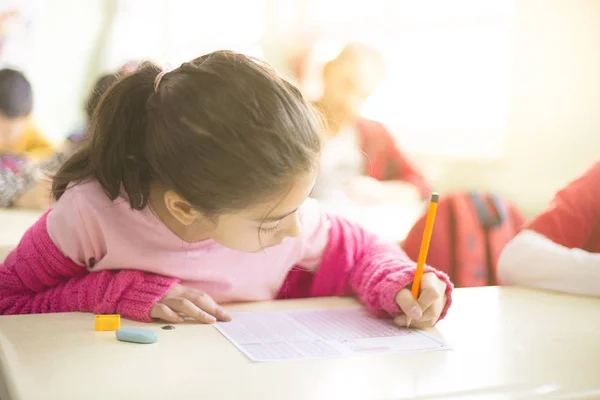 Kleine meisje student op zoek formulier met meerdere keuze-examen — Stockfoto