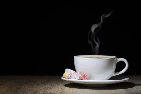 Copo de café cozido no vapor na mesa de madeira no escuro — Fotografia de Stock