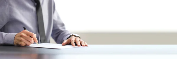 Mavi gömlekli ve kravatlı işadamı imzalı belge