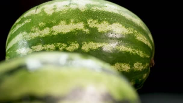 Två vattenmeloner på svart bakgrund — Stockvideo