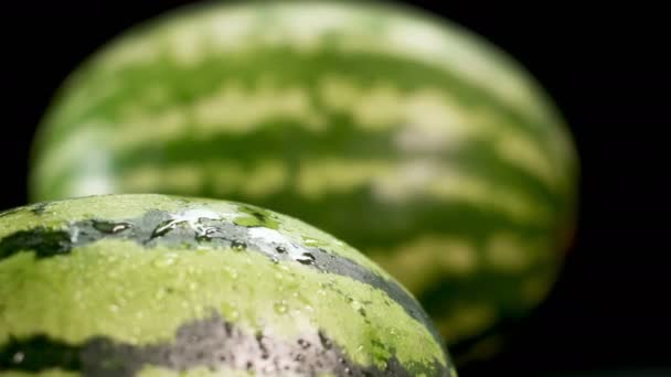 Zwei Wassermelonen auf schwarzem Hintergrund — Stockvideo