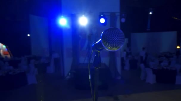 4K Microfone vocal com suporte em grande palco no salão de auditório ou átrio com sofá azul ao fundo — Vídeo de Stock