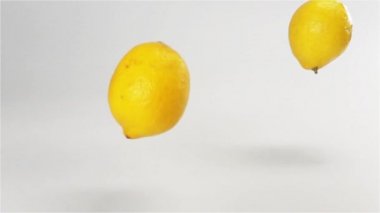 Birkaç limon beyaz ıslak yüzeyde düşme
