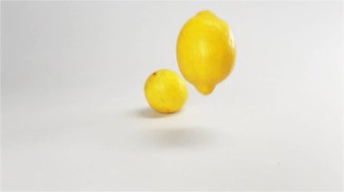 Birkaç limon beyaz ıslak yüzeyde düşme