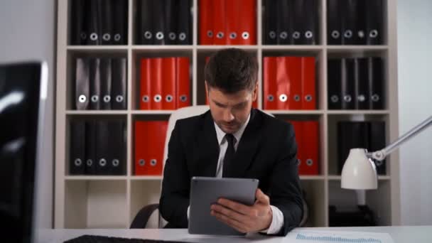 Podnikatel, psaní poznámek z iPadu v obchodní kanceláři — Stock video